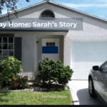 A single-story home with a silver car parked in the driveway and bright greenery in front. The scene symbolizes stability, hope, and a fresh start for Sarah and her son after overcoming homelessness through Harvest House’s Home Again program.