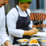 Restaurant workers preparing food in a commercial kitchen, representing working households struggling with Sarasota's cost of living